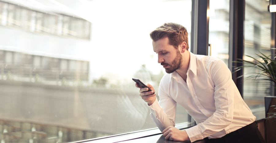 Lexacom 3 digital dictation - image of man using mobile phone to check his work on Lexacom 3 digital dictation 