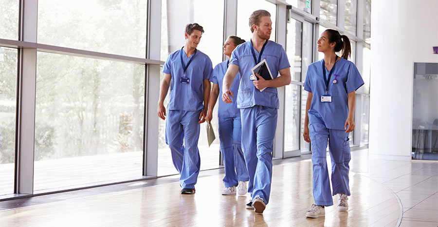 Lexacom Echo Speech Recognition software is discussed by doctors walking down the hall of a medical centre in their surgical scrubs